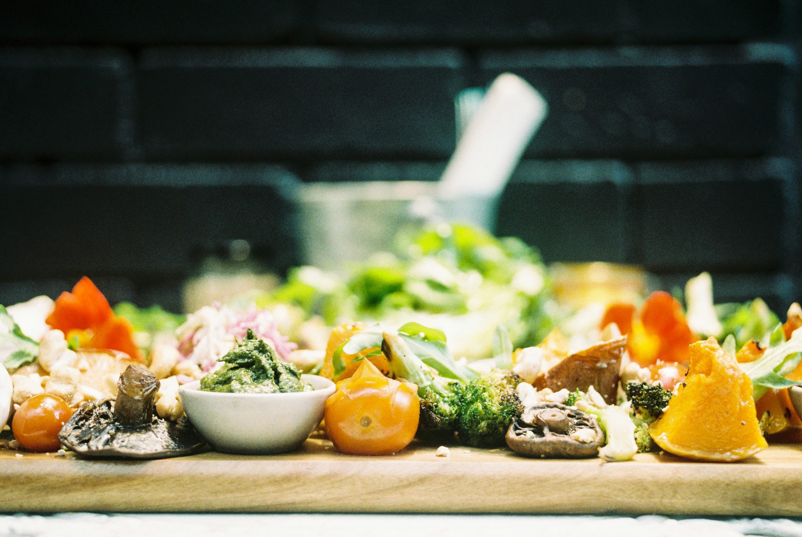 an assortment of yellow and green vegetables on a wooden table